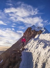 Roped alpinist on the mountain ridge