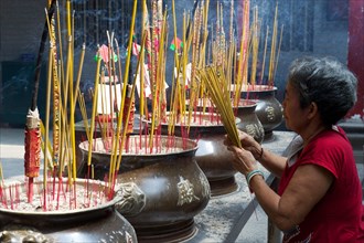 Woman lighting incense sticks