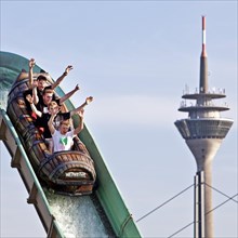 Four young men on the log flume in front of the Rhine Tower