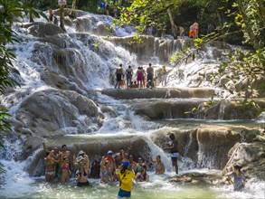 Tourists bathing and climbing the Dunn's River Falls