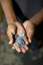 Panhandled money in the hands of a street child