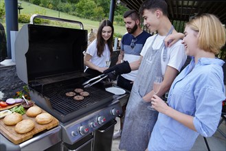 Young people grilling burgers