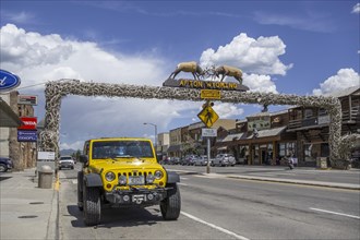 A jeep in front of the world's largest arch made of wapiti antlers