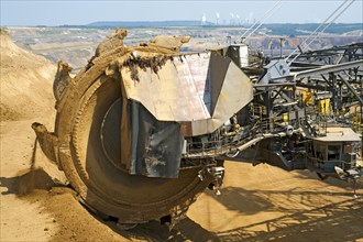 View over the bucket wheel of an excavator onto a coal power plant