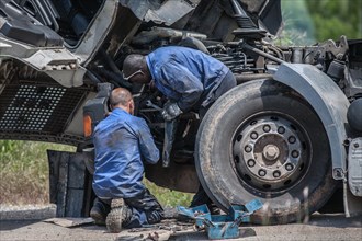 Two men repairing a truck