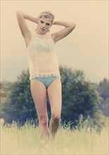 Young woman in lingerie posing outdoors