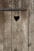 Weathered wooden door with a heart