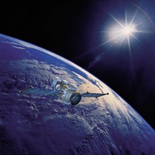 Geostationary orbit satellite above the Earth pointed toward the rising sun