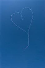 Two sailplanes are flying the shape of a heart in the air