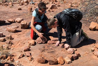 Two tourists looking for fossilised dinosaur footprints