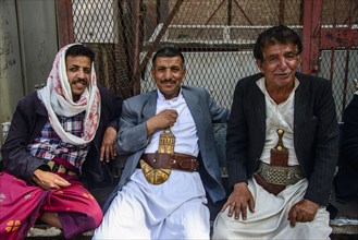 Men with their djambias sitting in front of a house in the old city