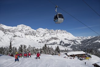 Skiers on ski slope in front of mountain scenery