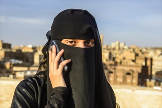 Veiled young woman on her mobile