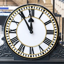 Railway station clock showing 11:55