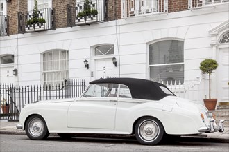A Rolls Royce Silver Cloud parked in front of a row of houses in the exclusive district of Knightsbridge