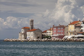 View of the town of Piran with lighthouse and the Church of Our Lady of Health