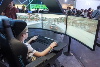 Junge plays simulation of a car race at Gamescom