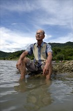 Aged man gazing over the sea after losing almost his entire family to the 2004 tsunami