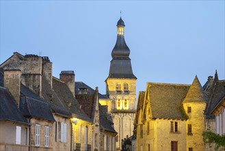 Old houses on Place de la Liberte and tower of Cathedrale Saint-Sacerdos at dusk