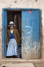 Old woman standing in a doorway