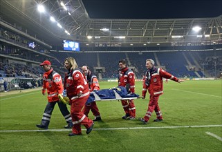 Injured football player being carried off the field by attendants from the Red Cross