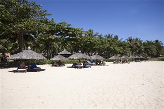 Beach with palm umbrellas at the Saigon Mui Ne Resort