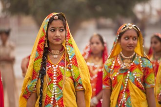 Young women in typical colourful traditional Rajasthani costume at the camel market and livestock market