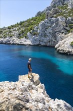 Man standing on rocky outcrop overlooking the Calanque de Sugiton bay