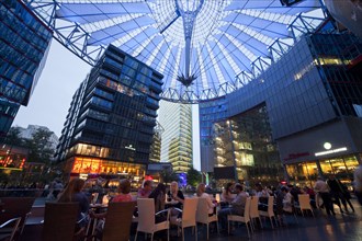 The illuminated dome and restaurants in the forum of the Sony Center