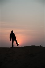 Man silhouetted against sunrise