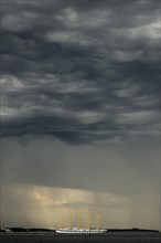 Five-master sailing ship in front of Crveni Vrh in thunderstorm atmosphere seen from Piran