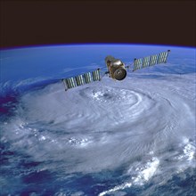 Weather monitoring satellite orbiting over a hurricane