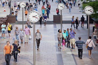 People in a square with clocks