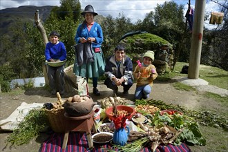 Farming family in the Andes in front of their products