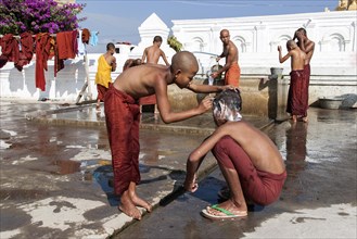 Novice monks during the morning bath with a shaving of the head in the Shwe Yaunghwe Kyaung Monastery
