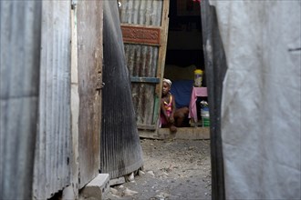 Girl in the entrance of a shack