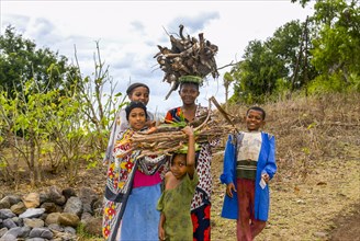 Smiling girls carrying firewood