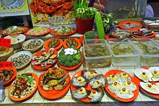 Dishes of a seafood restaurant at the night market in Temple Street
