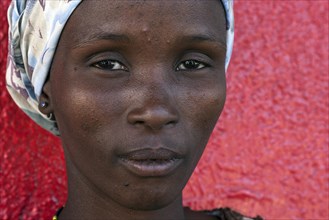 Namibian woman in front of a red wall