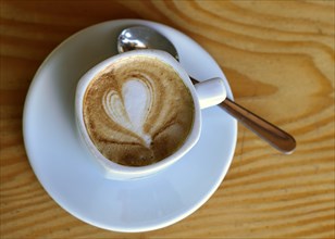 Cup of cappuccino with milk foam in a heart shape