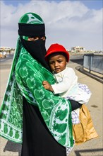 Fully veiled Muslim woman and her child