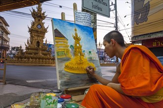 Buddhist monk painting a clock tower
