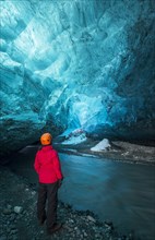 Young woman in ice cave below the Vatnajokull Glacier