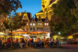 Outdoor cafes in Fischmarkt square with Great St. Martin Church in the evening