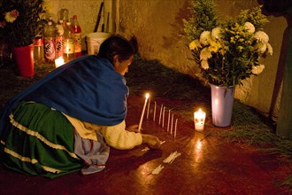 Indigenous Mayan woman lighting candles in a church