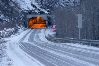 Wintry road and lit tunnel