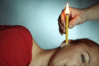 Woman being treated with an ear candle