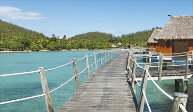 Wooden walkway to overwater bungalows in the sea