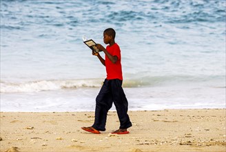School boy walking along the beach