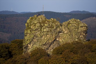 Bruchhauser Steine rocks with a group of visitors at the summit cross